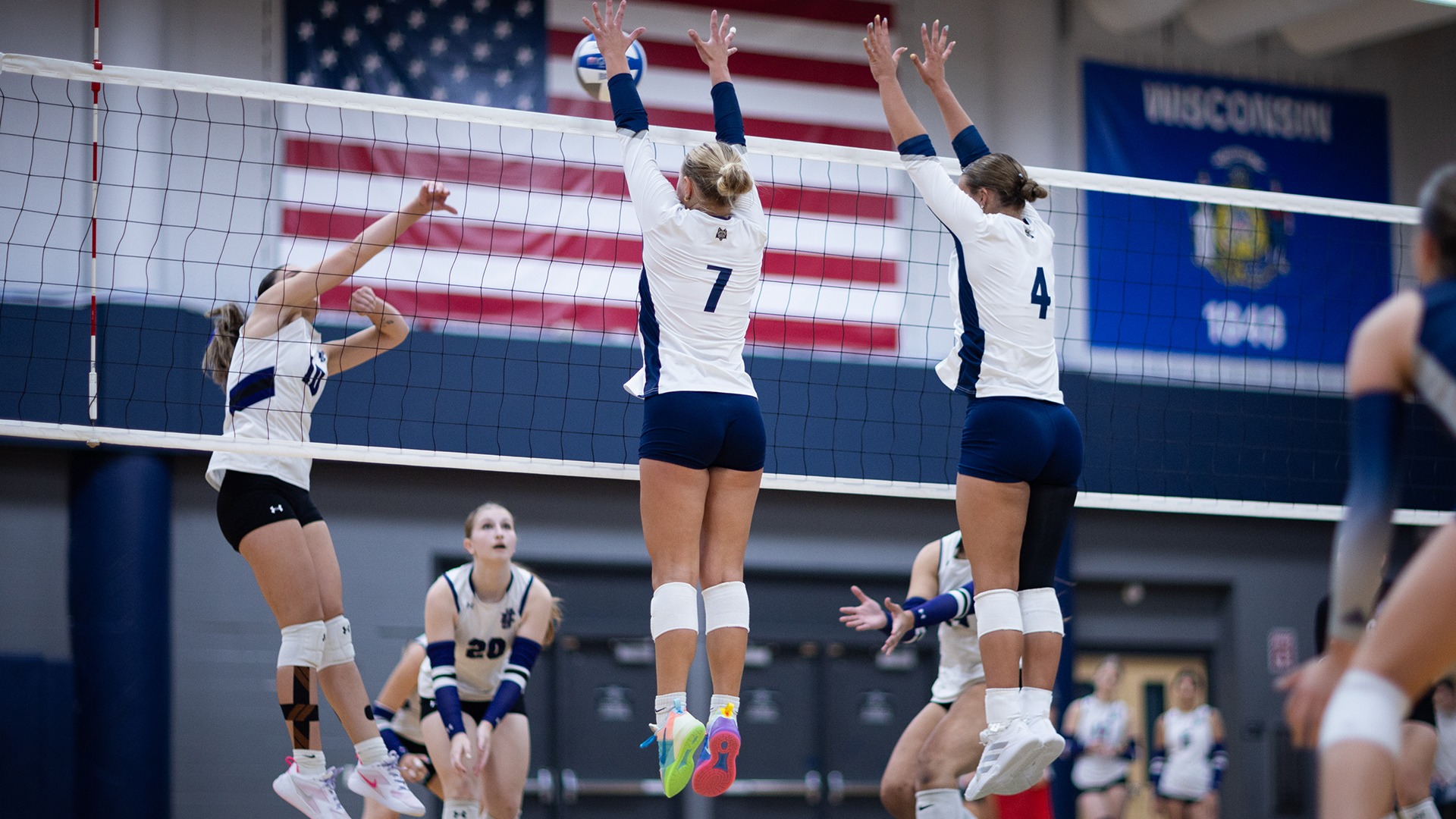 Sam Schultz and Makayla Dallas both jump to attempt a block of an opponents attack.
