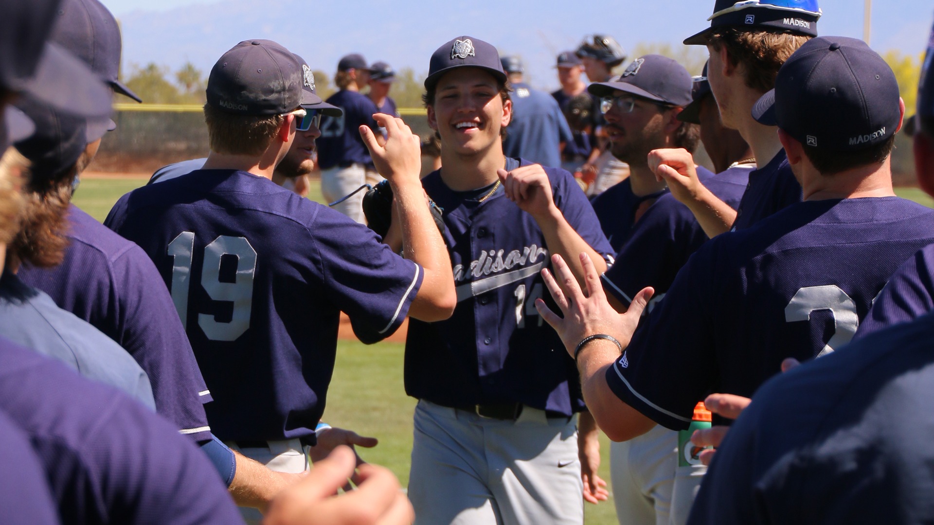 Tavian Shramek gets high fives and fist bumps from teammates as he exits the field.
