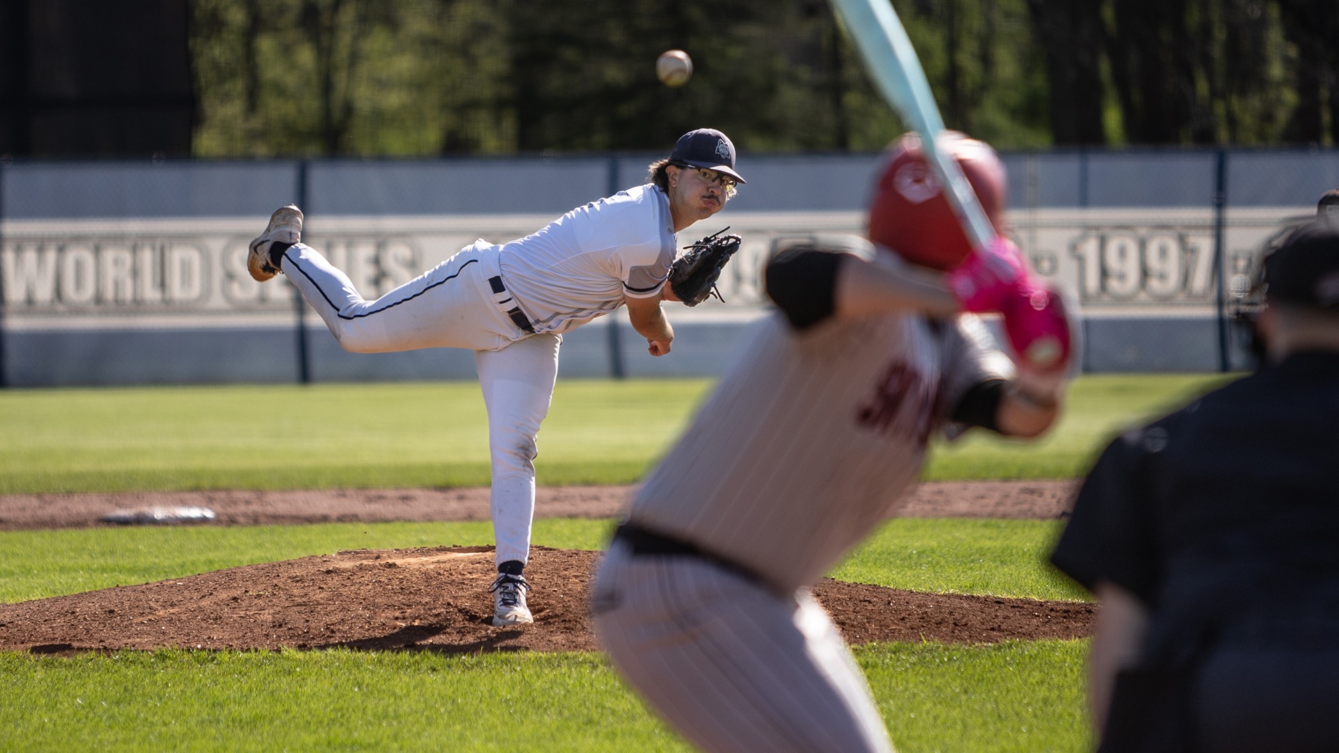 Noah Musolf throws a pitch as the batter and umpire aware in the foreground at Robin Roberts Field.