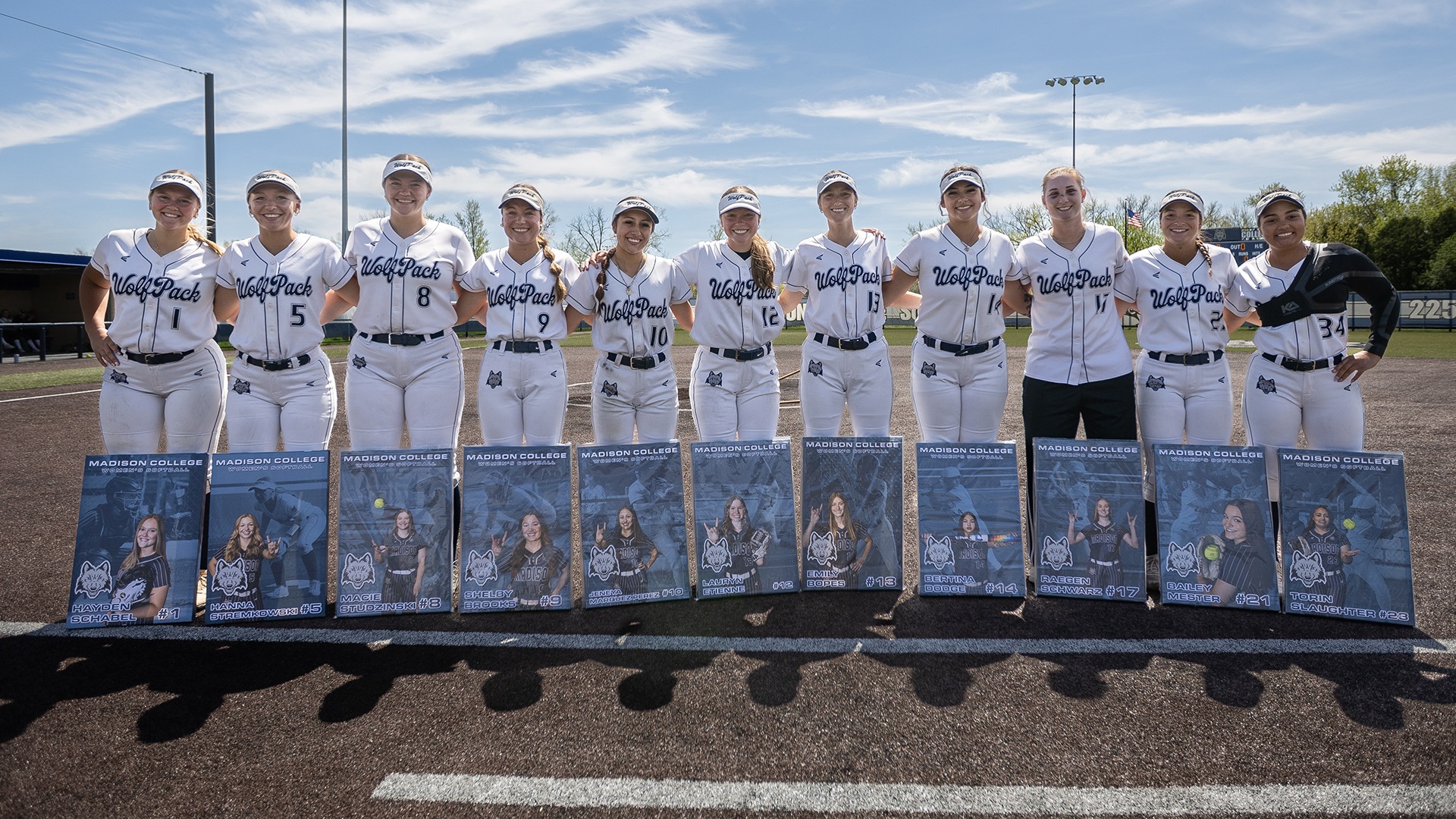 Members of the Softball Sophomore Class of 2026 poses at Goodman Softball Field with canvases they were gifted by the team.