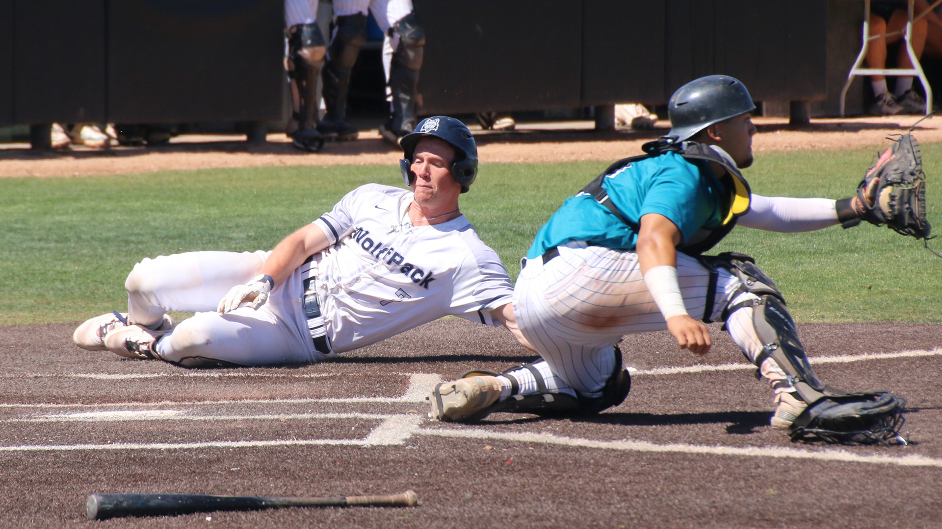 Sam Moses slides into home as the opposing catcher awaits a throw.