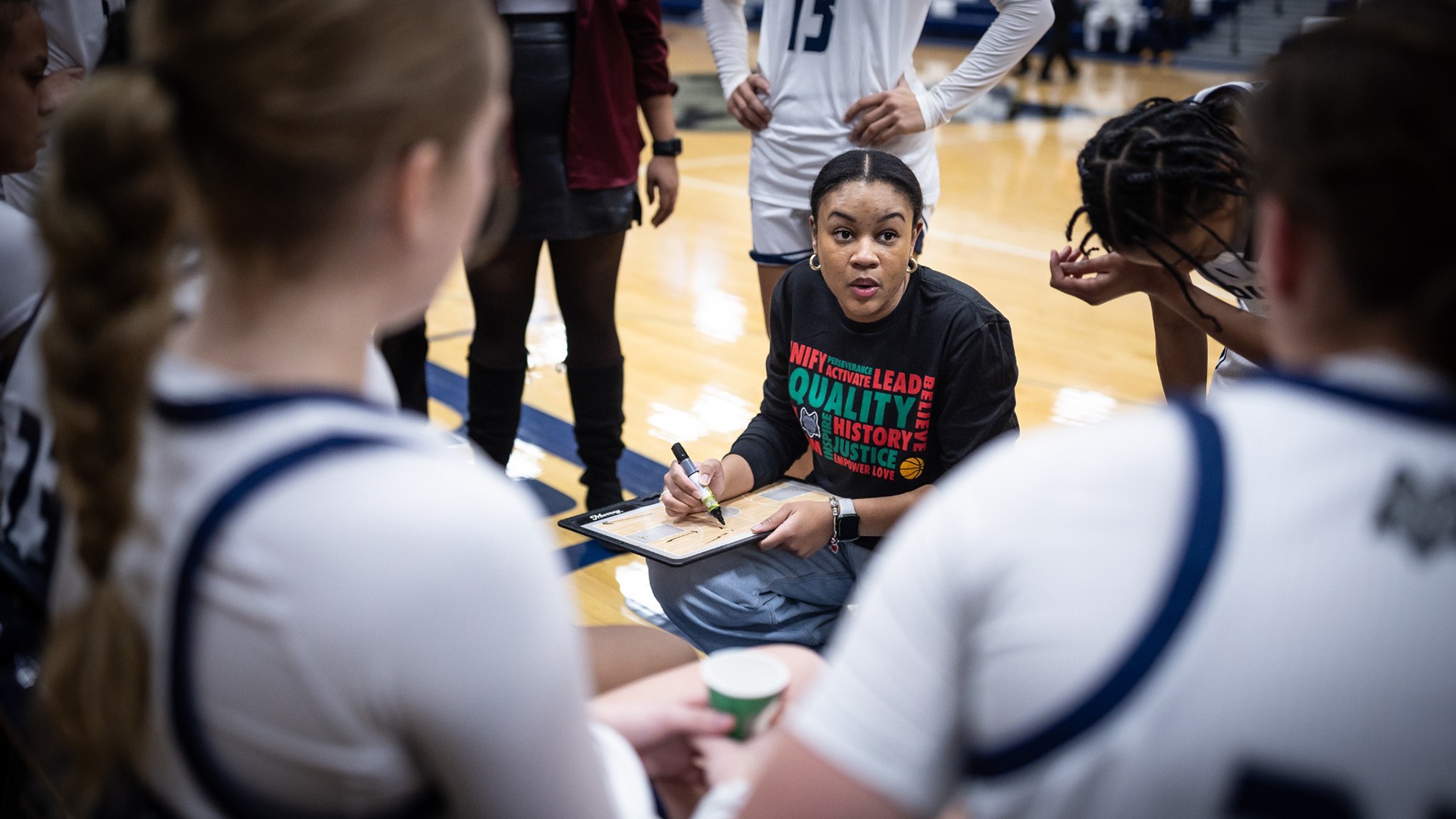 Women's basketball coach Angel Whetstone talks to her team during a timeout.