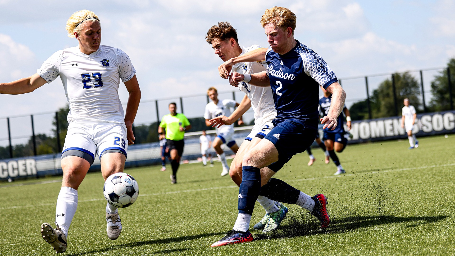 Owen Counsell battles two opponents for possession of the ball