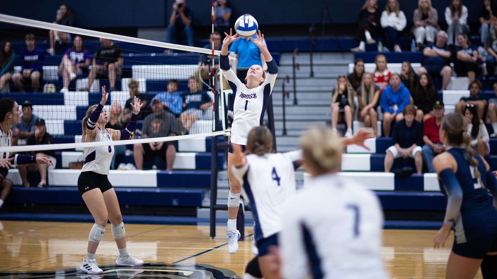 Gretchen Kammerer sets a volleyball as teammates begin their approach