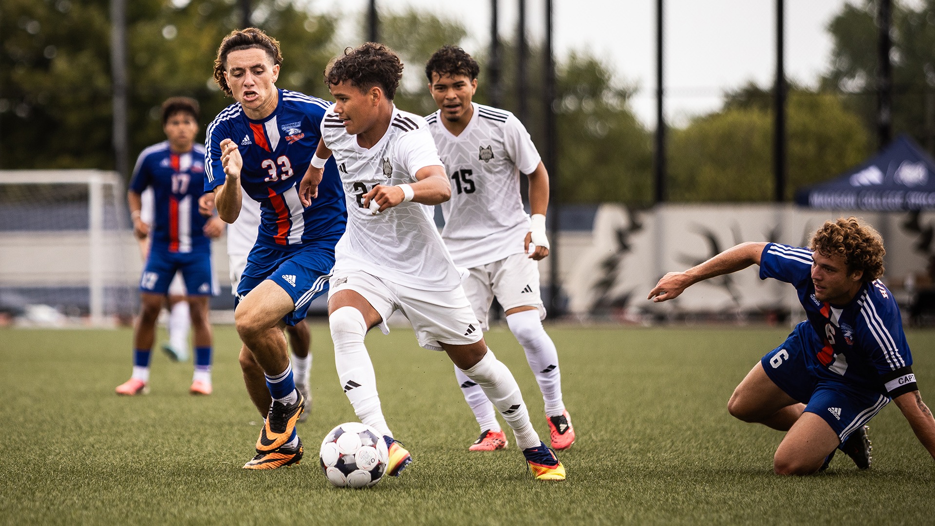 Cris Quezada dribbles the ball past two defenders