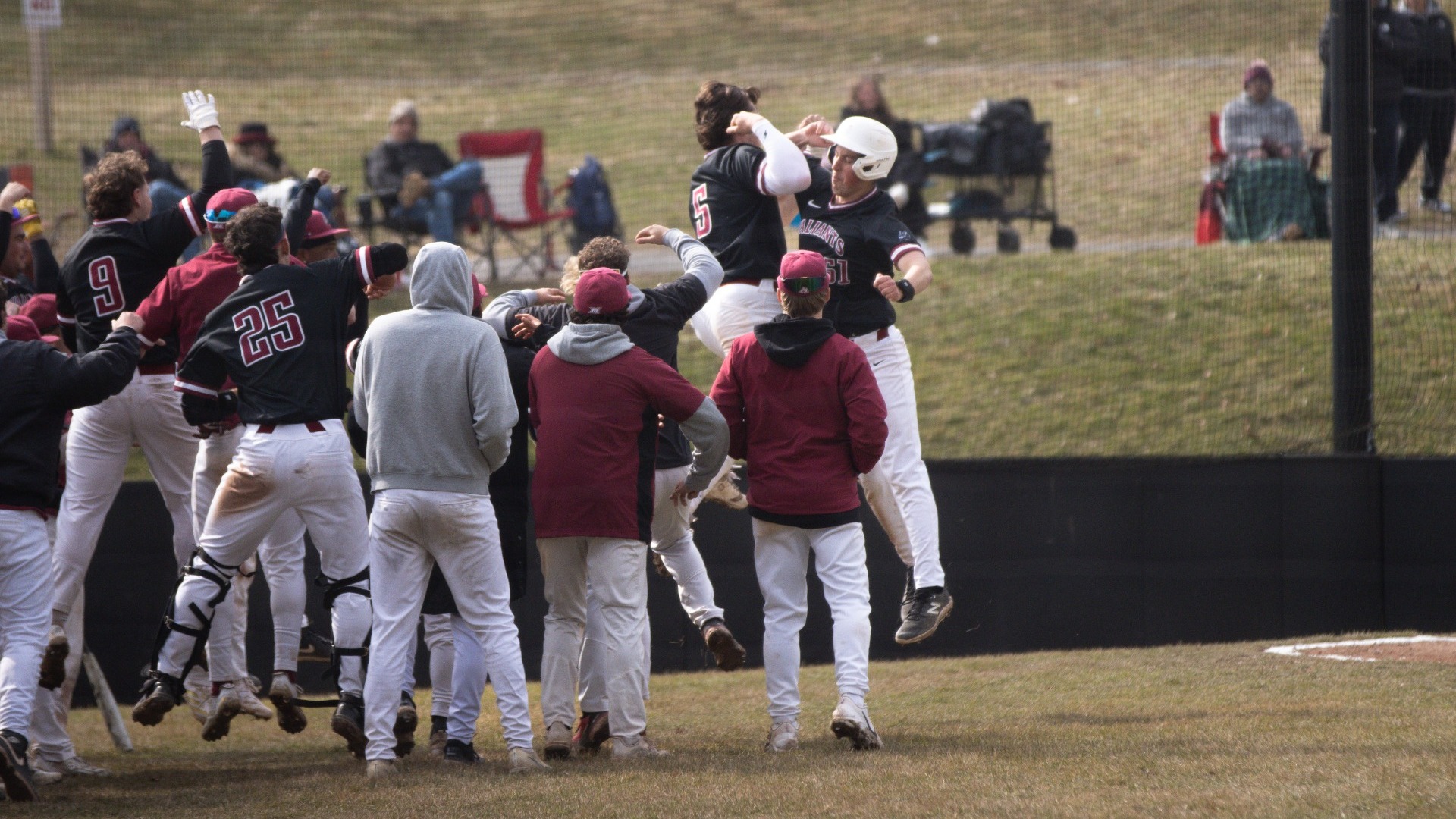 white jumping into a celebration huddle after a home run