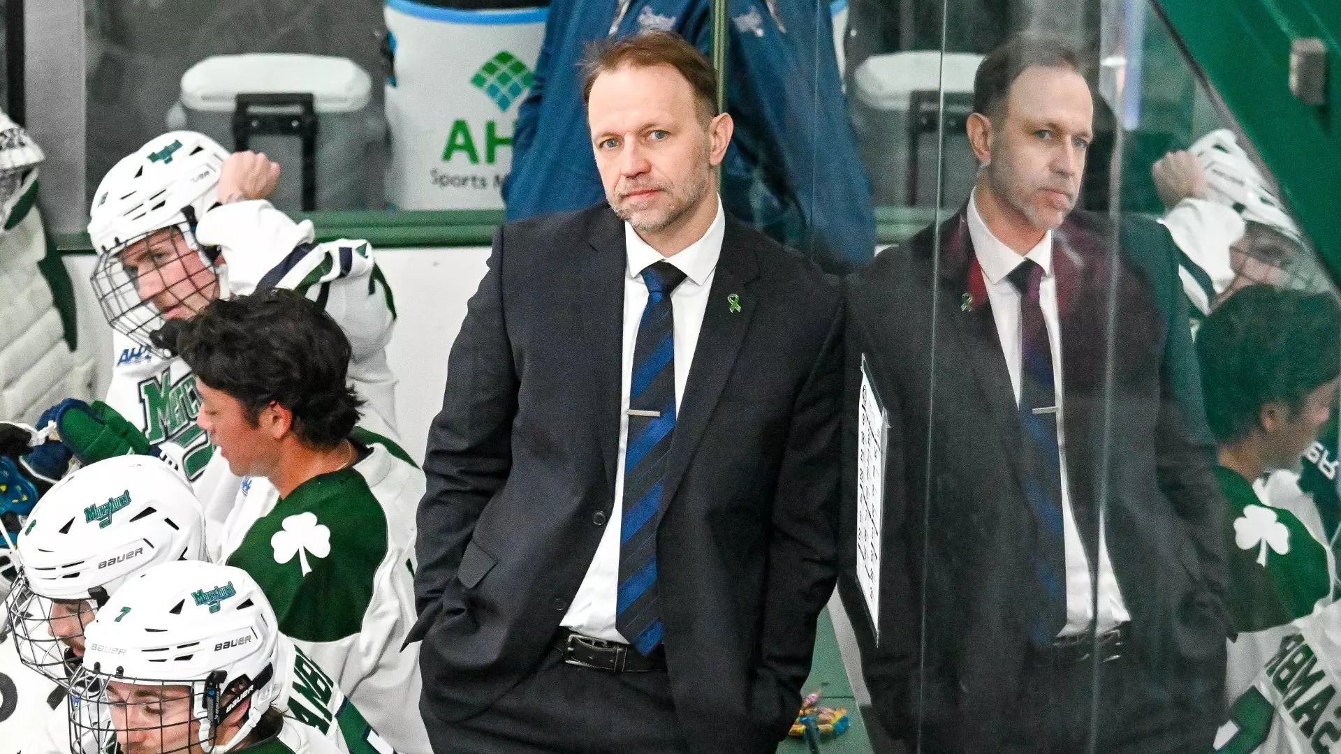 Karlis Zirnis leans up against the glass at a hockey game