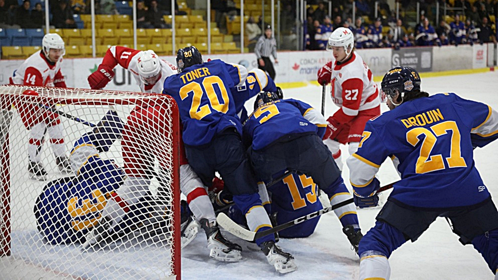 CROWDED CREASE: Charles Boutin (11) pokes at loose puck in Moncton crease while Xavier Fortin (27) looks on