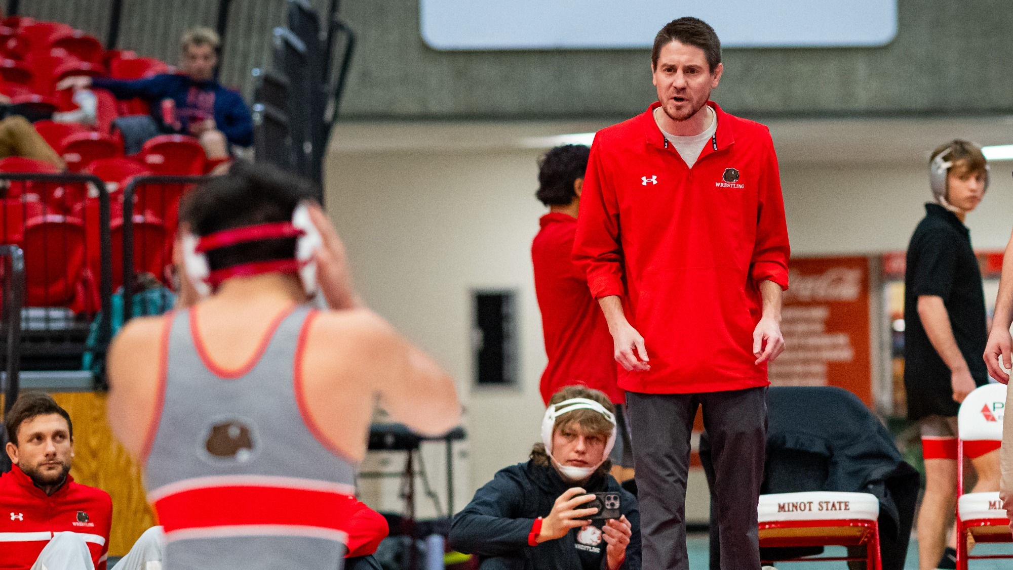 Evan Forde coaching men's wrestler against Bismarck State