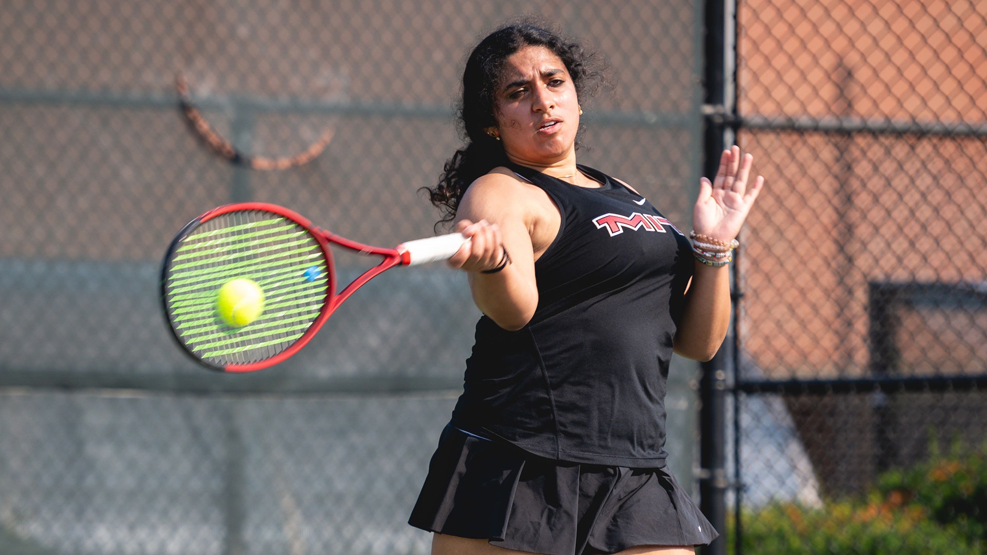 Nishi Gandra hitting the tennis ball with her racket