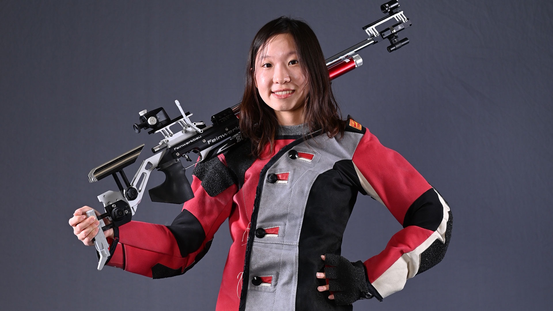 Phoebe Xu standing while holding her rifle over her shoulder