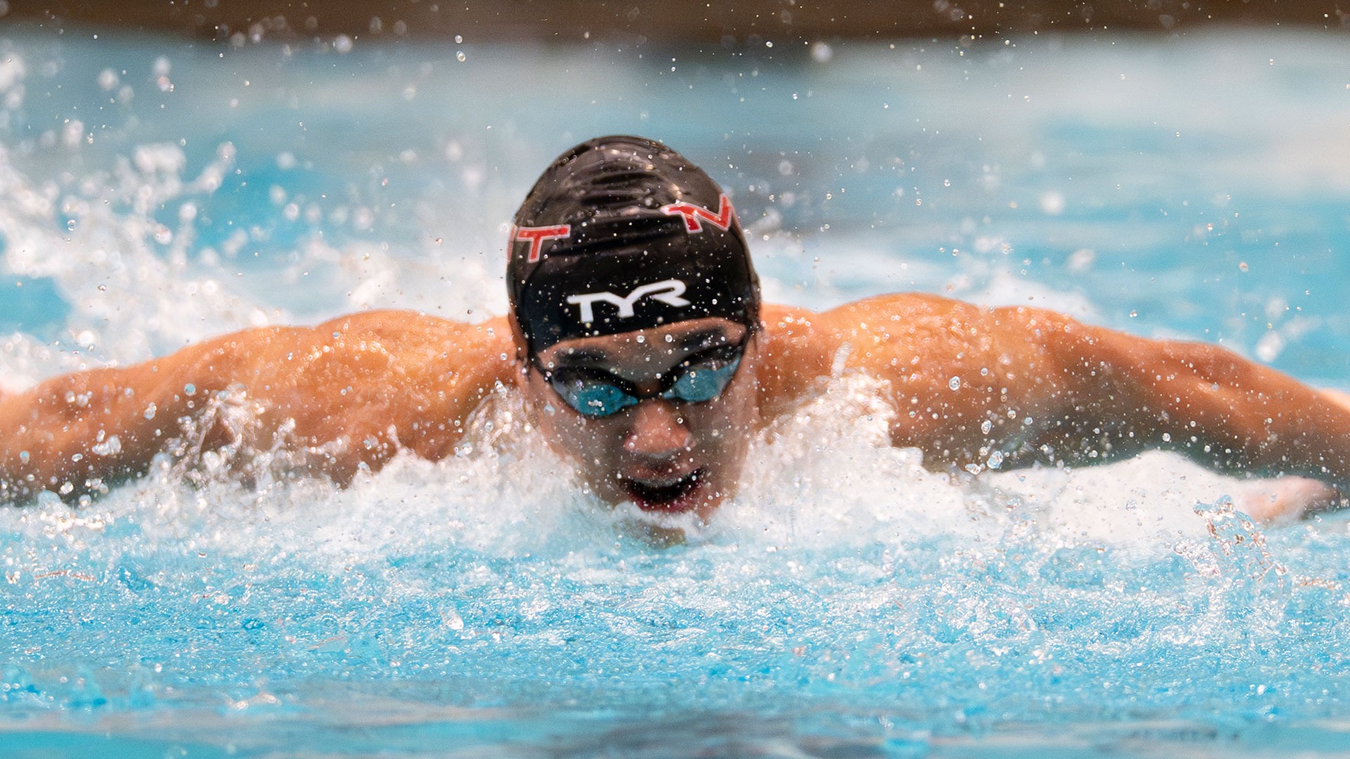 A MIT men's swimmer swimming in a competition