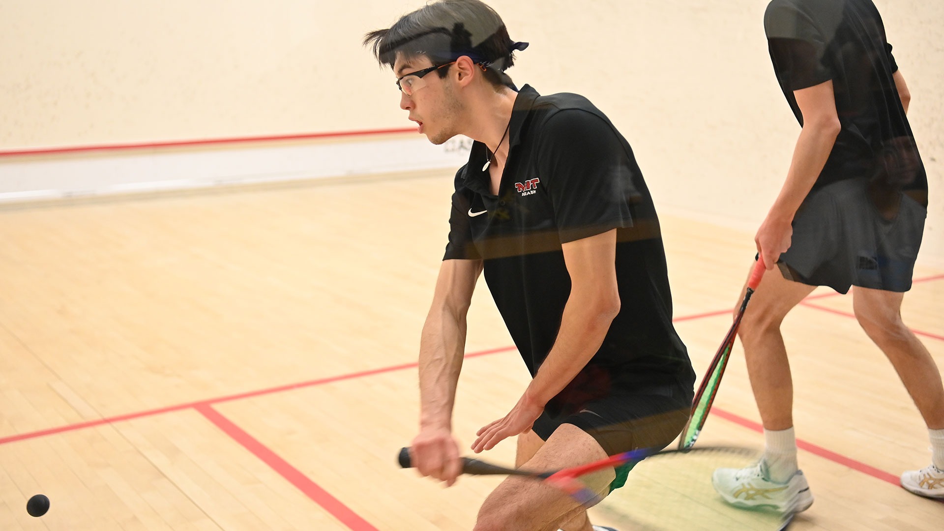 Hyun Su Price hitting a squash ball