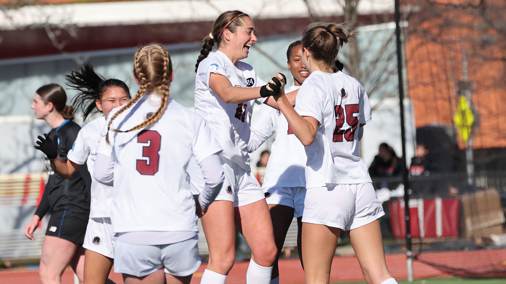 A group of MIT women's soccer players celebrating after a goal