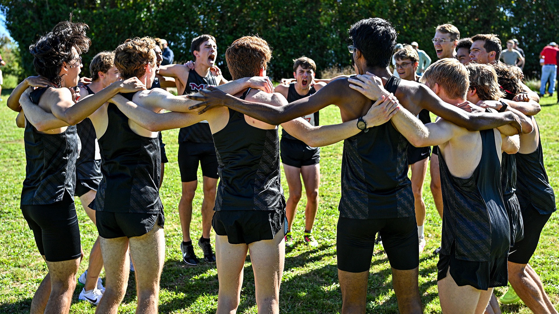 men's cross country team huddle cheering