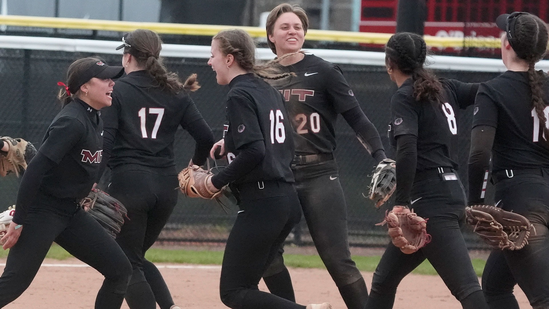 The MIT softball team celebrating coming off the field