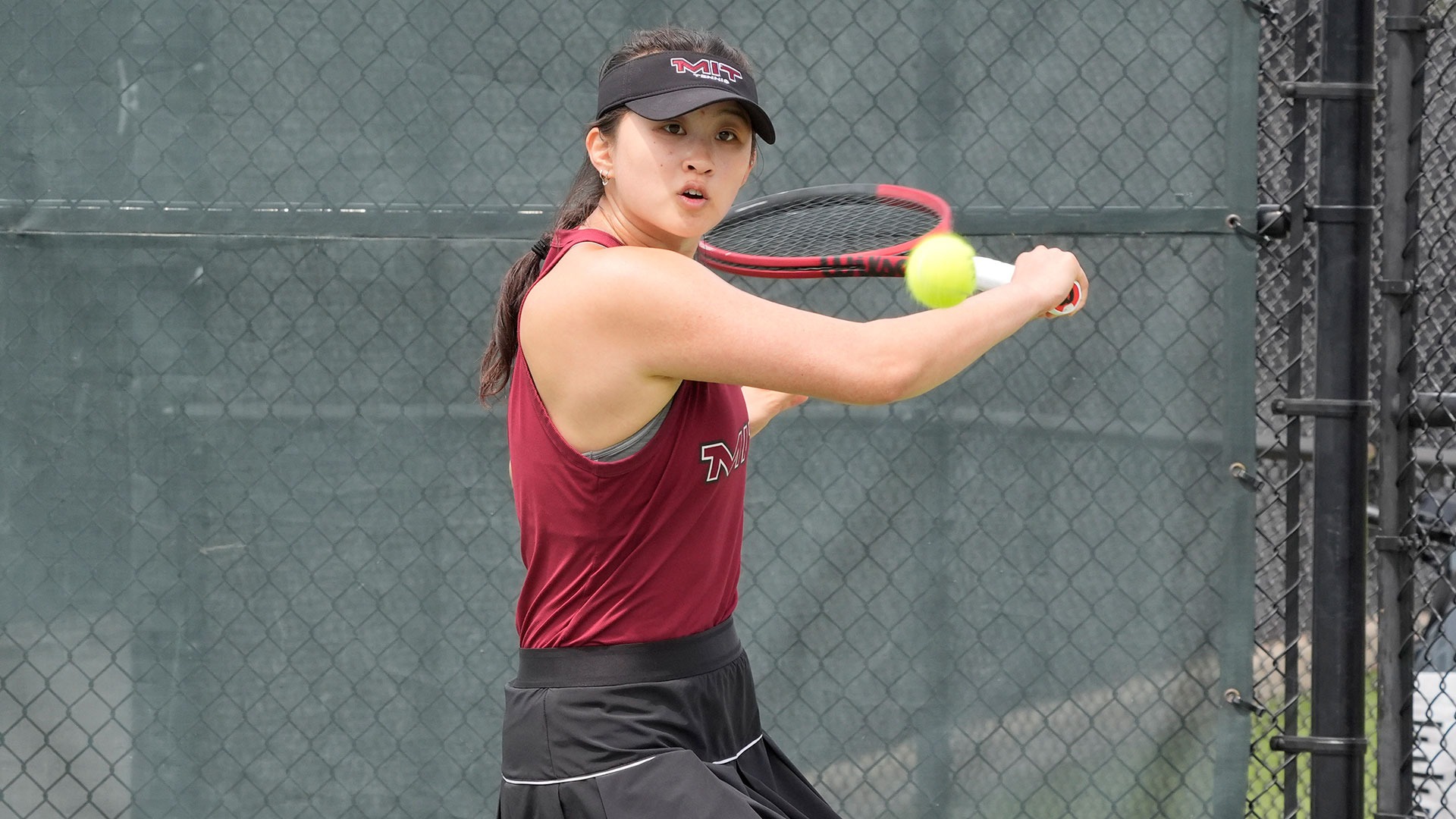 Jay Lu in the process of hitting a tennis ball with her racket