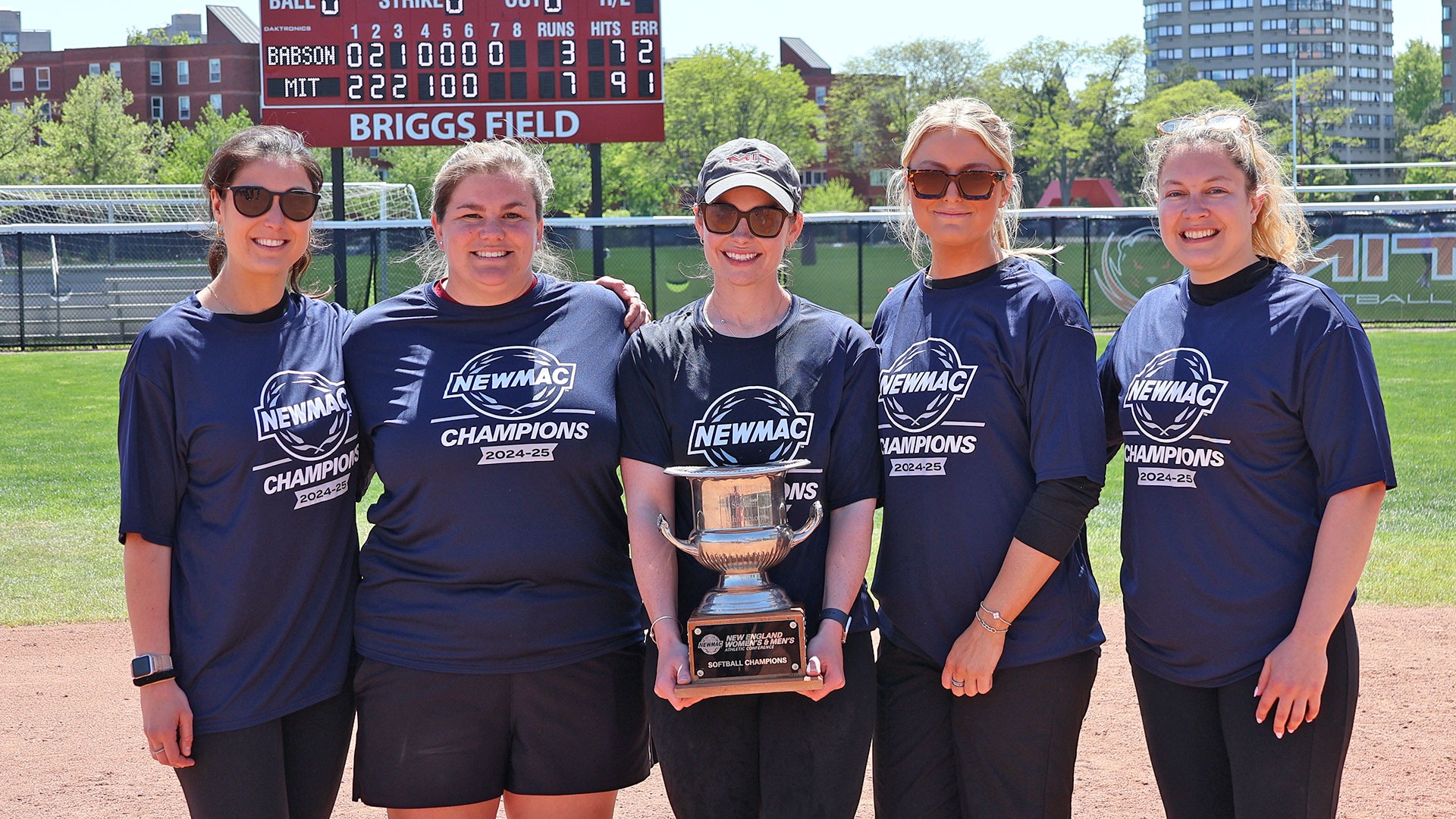 The MIT coaching staff holding the NEWMAC Trophy