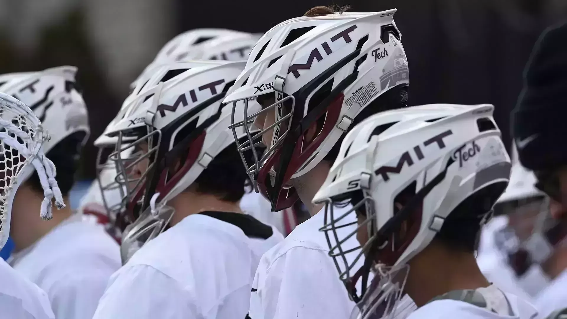 The men's lacrosse team standing in a huddle