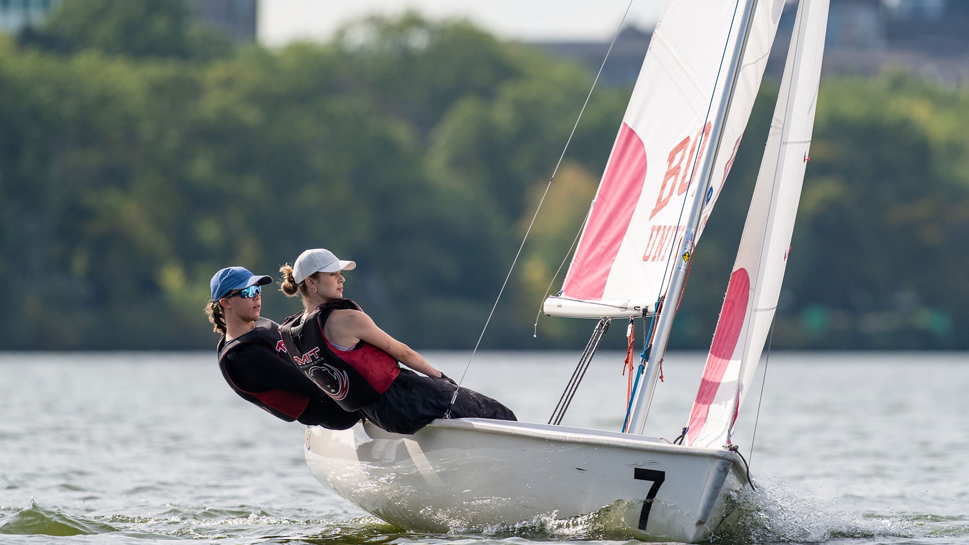 Two MIT Sailors on a boat on the river