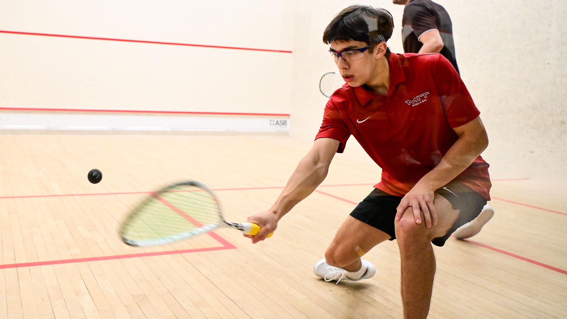 Zachary Starr hitting a squash ball