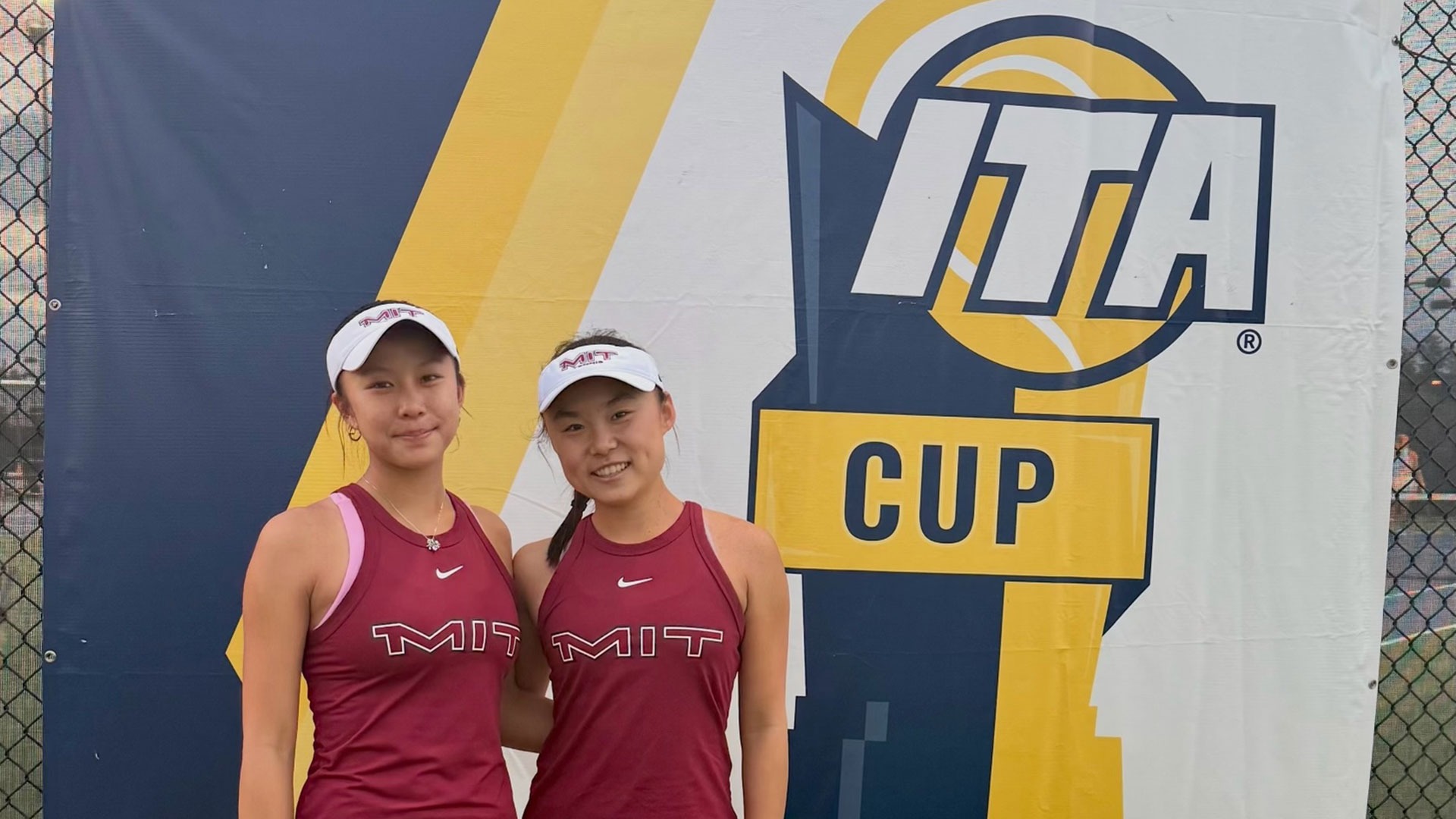 Claire Zhou and Sophia Yang standing in front of an ITA Cup banner