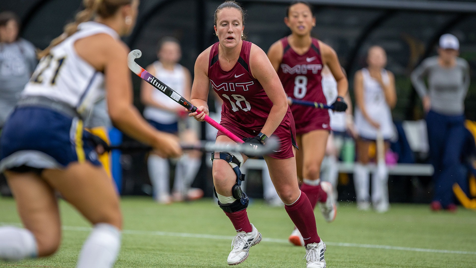 Janie Thomas running down the field holding her field hockey stick
