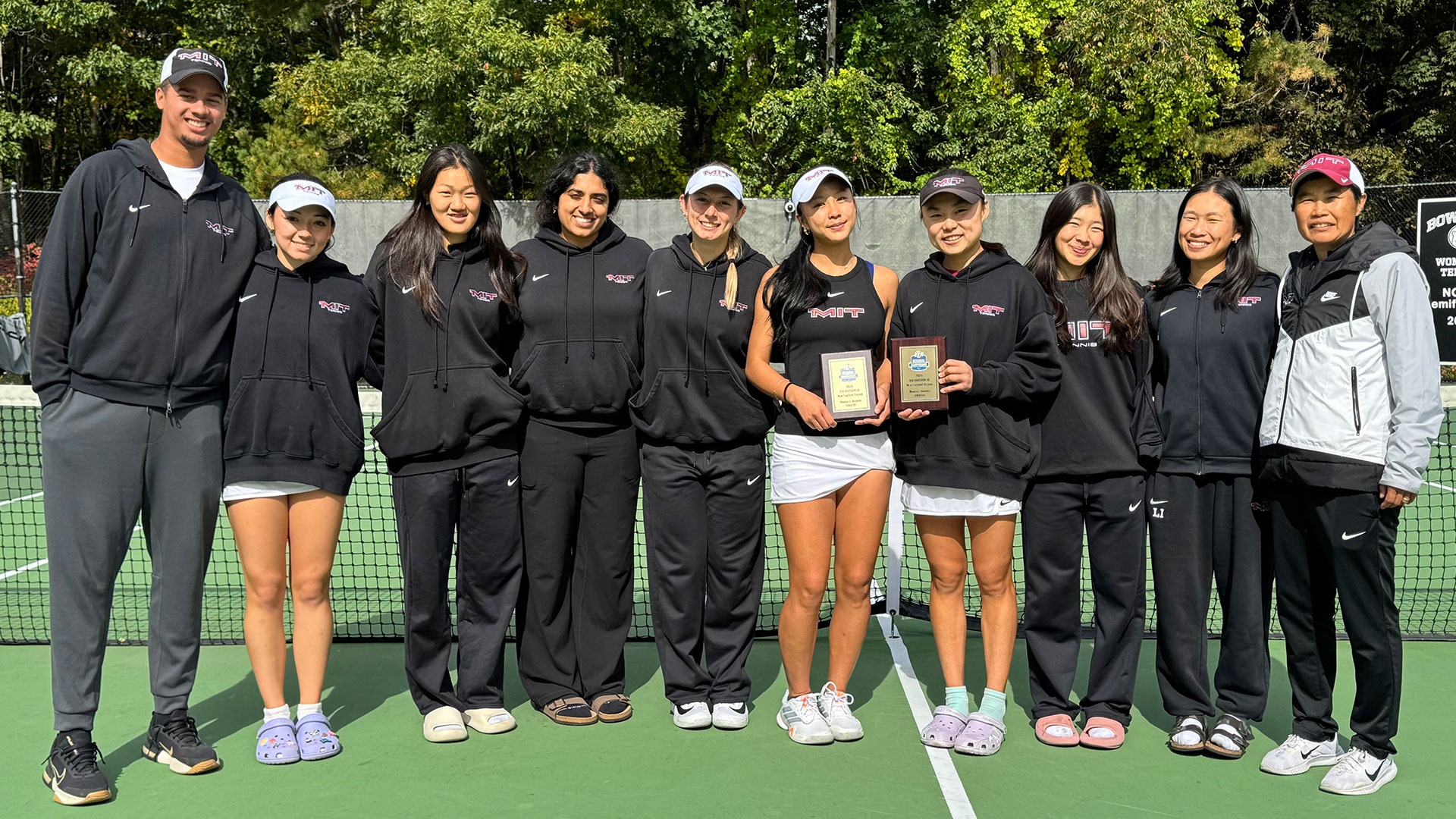 Members of the MIT women's tennis team in a group photo with Claire Zhou and Sophia Yang holding plaques