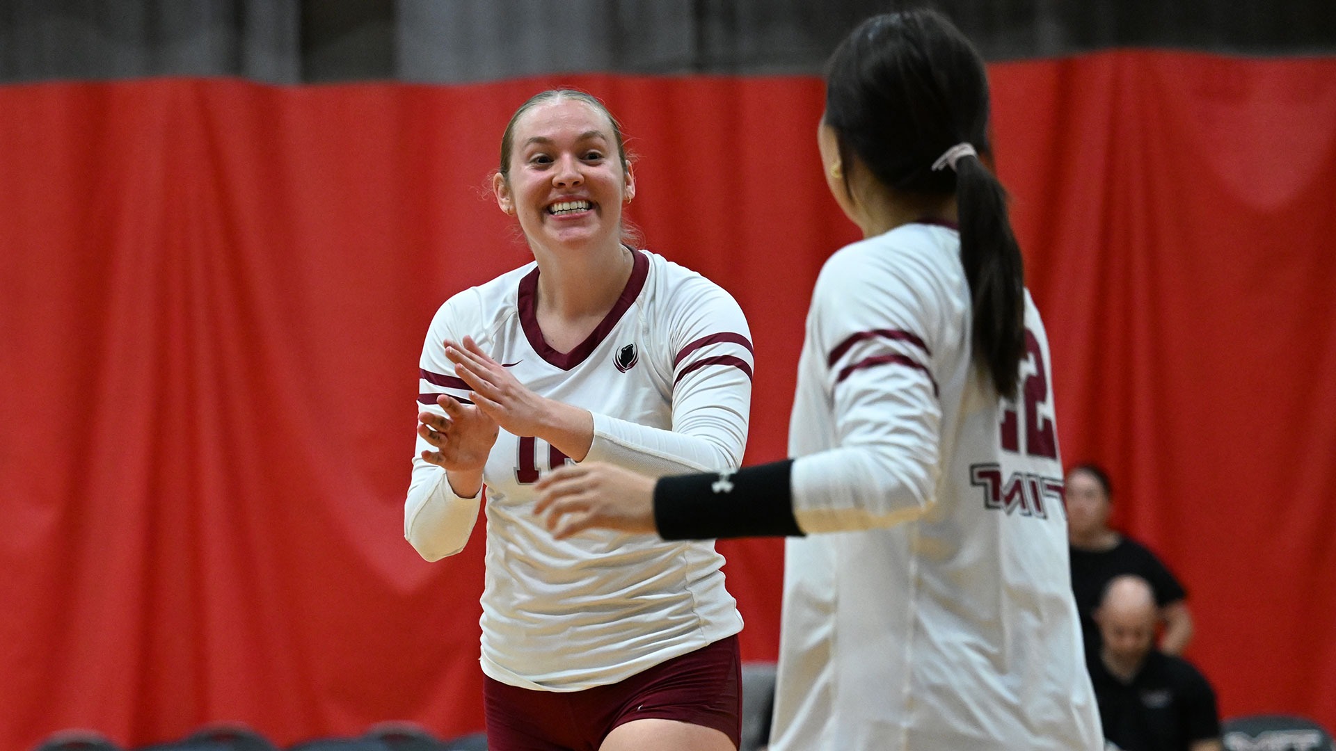 Kayleigh May smiling on the volleyball court