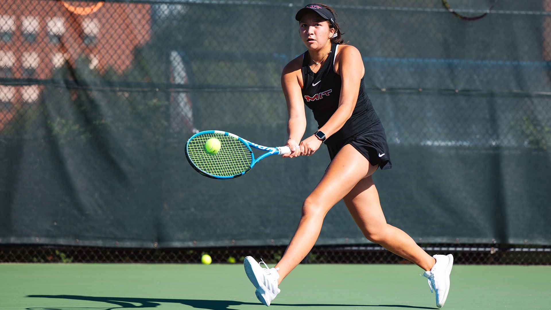 Anselma Petrie hitting the tennis ball with her racket
