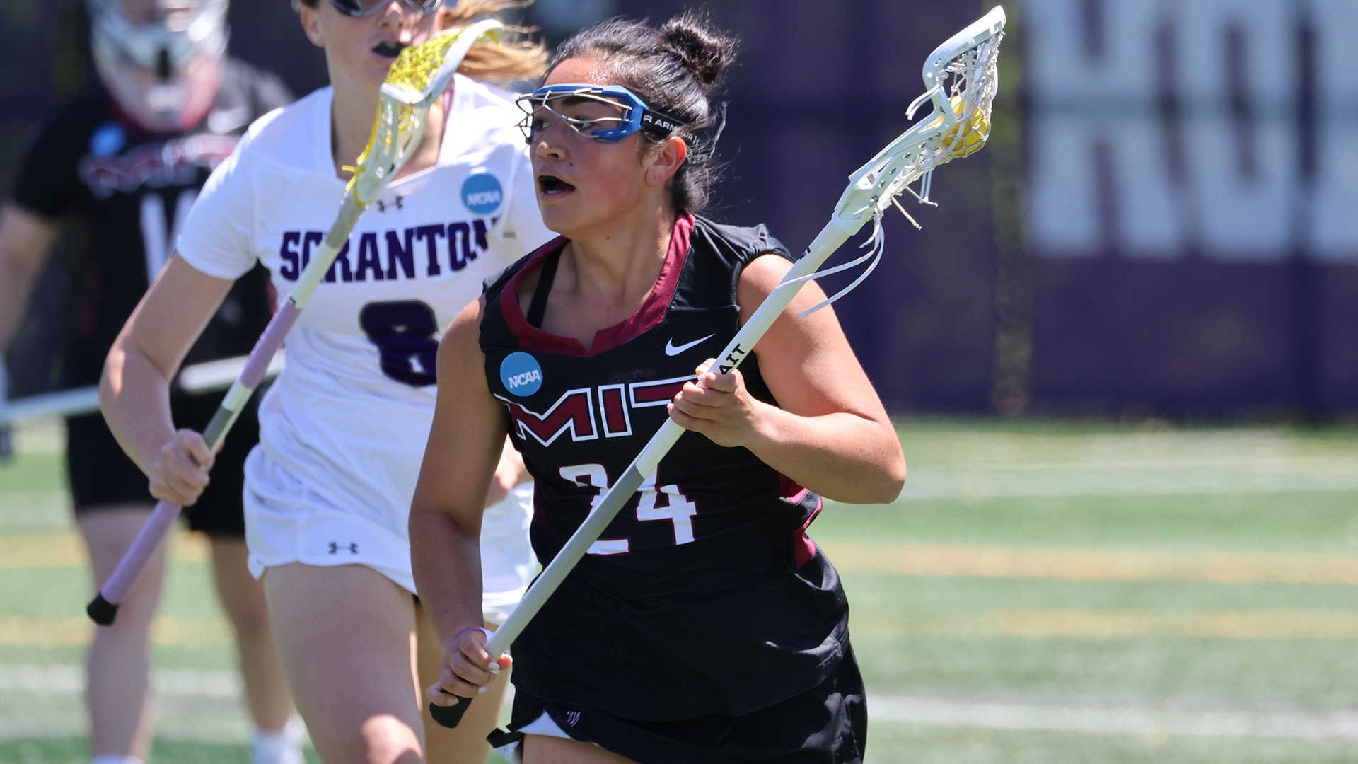 Jillian Butler running down the field the with the ball in her lacrosse stick