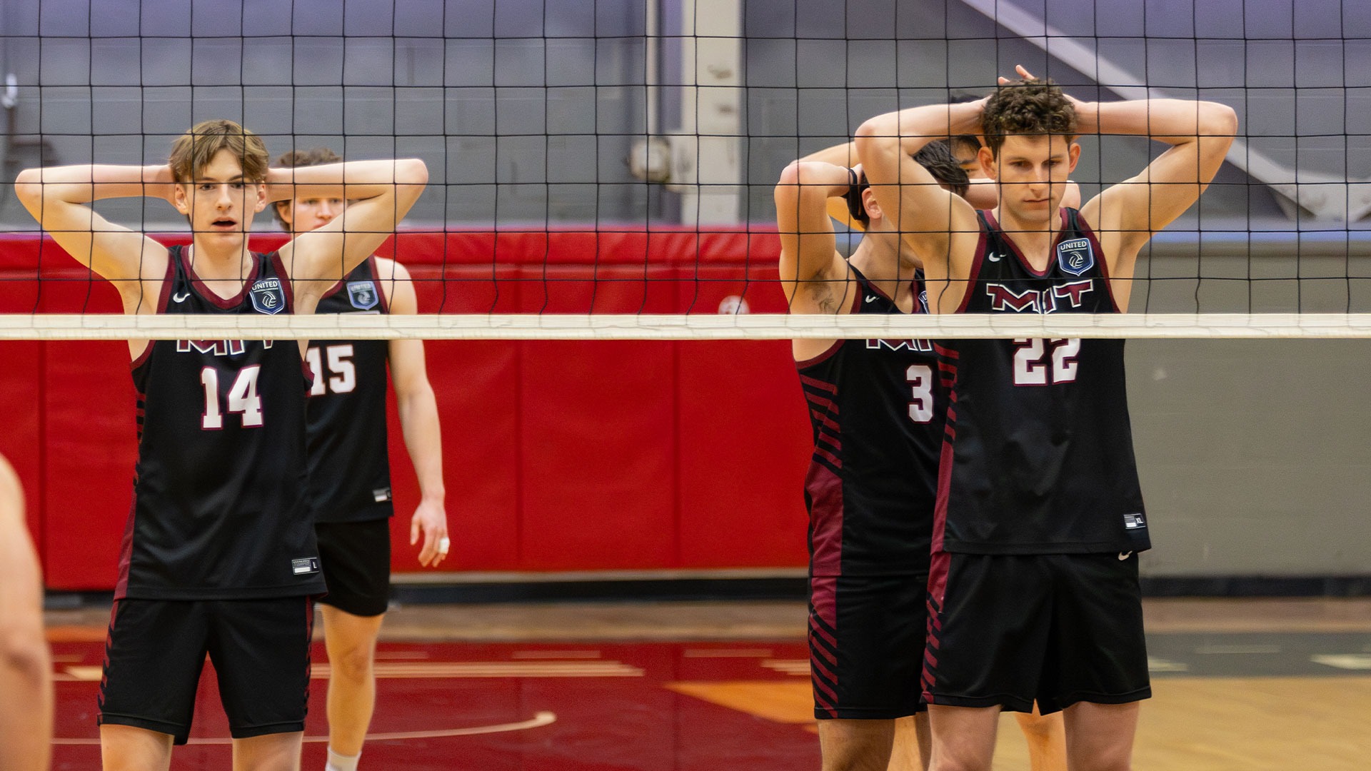 Members of the MIT men's volleyball team lined up at the net