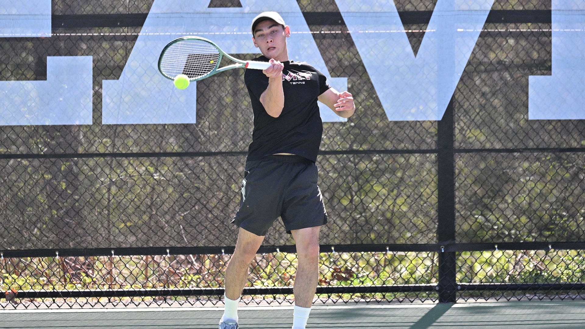 Grant Gallagher hitting a tennis ball