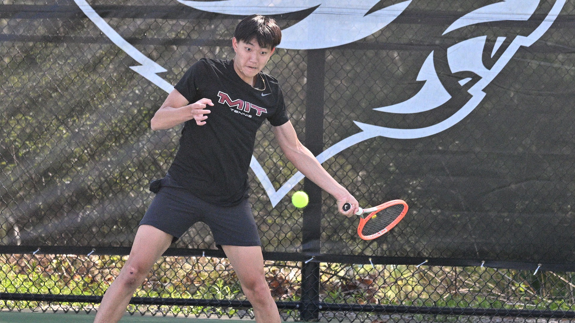 Adam Sun hitting a tennis ball