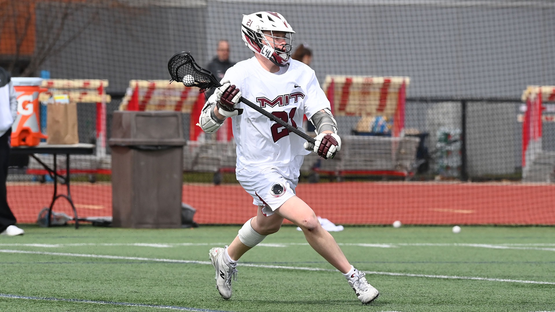 Garrett Campanga running on the field a ball in his lacrosse stick