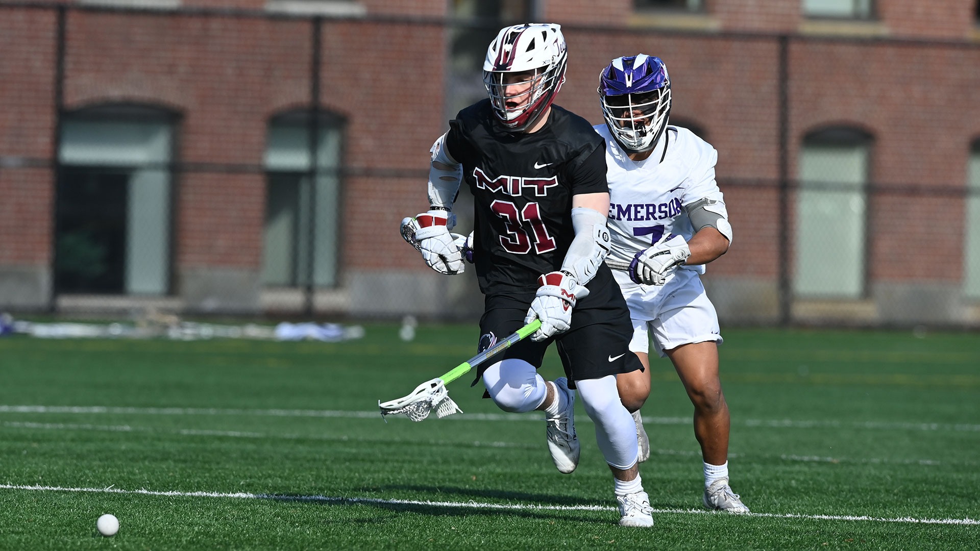 Kaden Fenno running to pick up a lacrosse ball with this stick