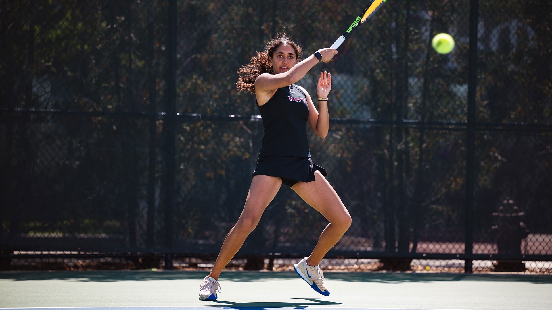 Alaina Kolli hitting the tennis ball with her racket
