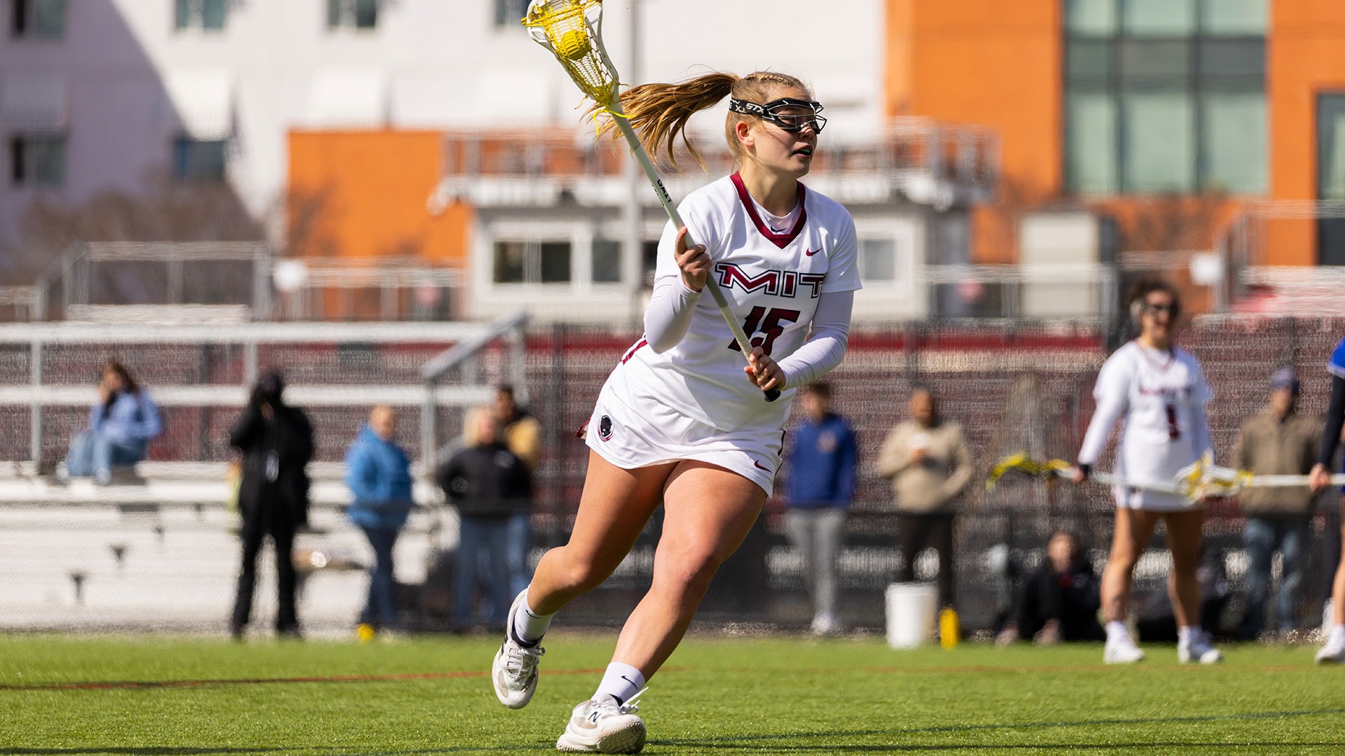 Laura Day running down the field with the ball in her lacrosse stick