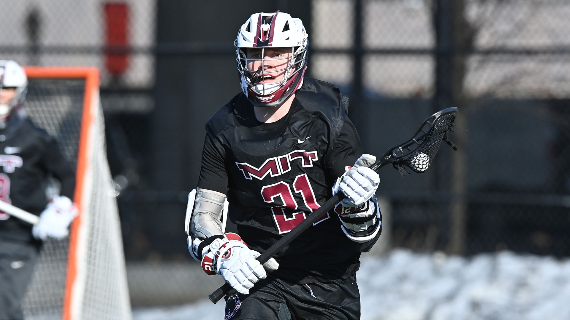 Garrett Campagna running down the field with the ball in his lacrosse stick