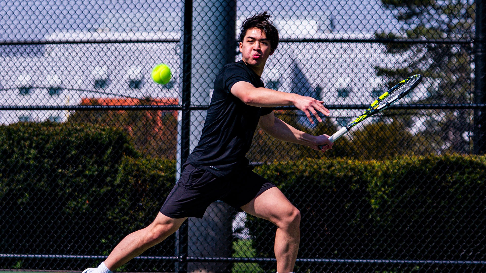 Ethan Nguyen hitting a tennis ball