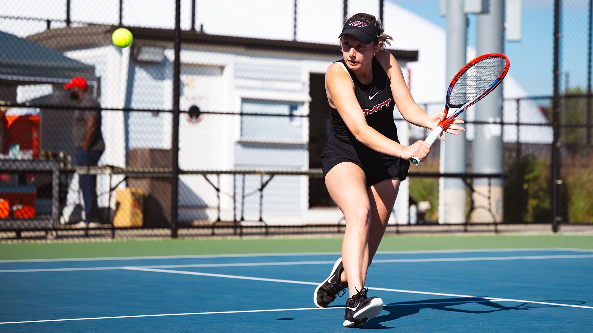 Anastasia Samets in the process of hitting a tennis ball with her racket