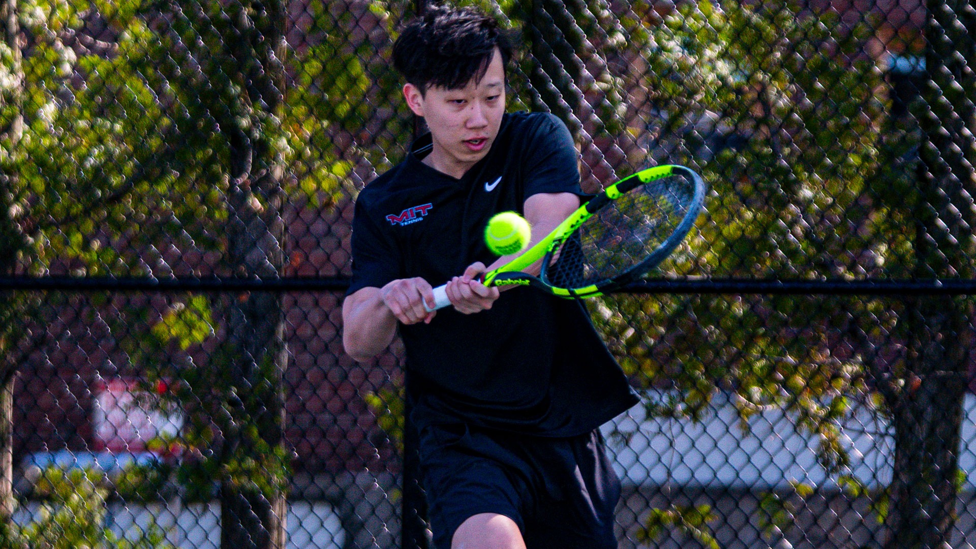Adam Sun hitting a tennis ball