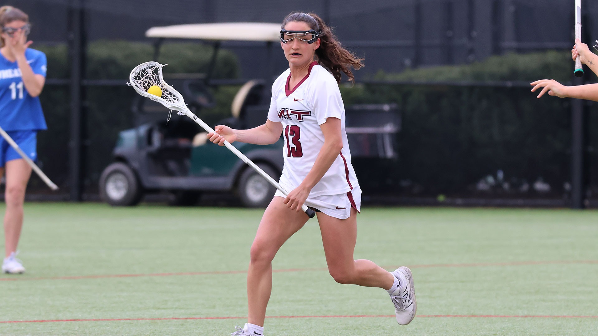 Gwen Flusche running down the field with the ball in her lacrosse stick