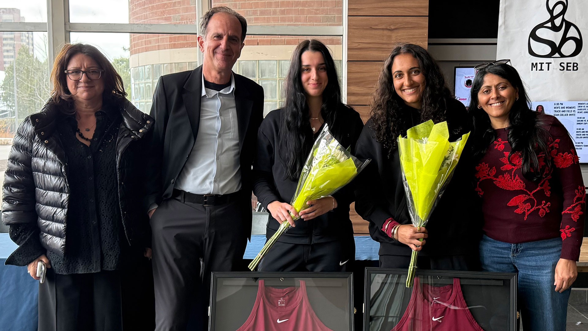 Artemis Pados and Alaina Kolli standing with their families