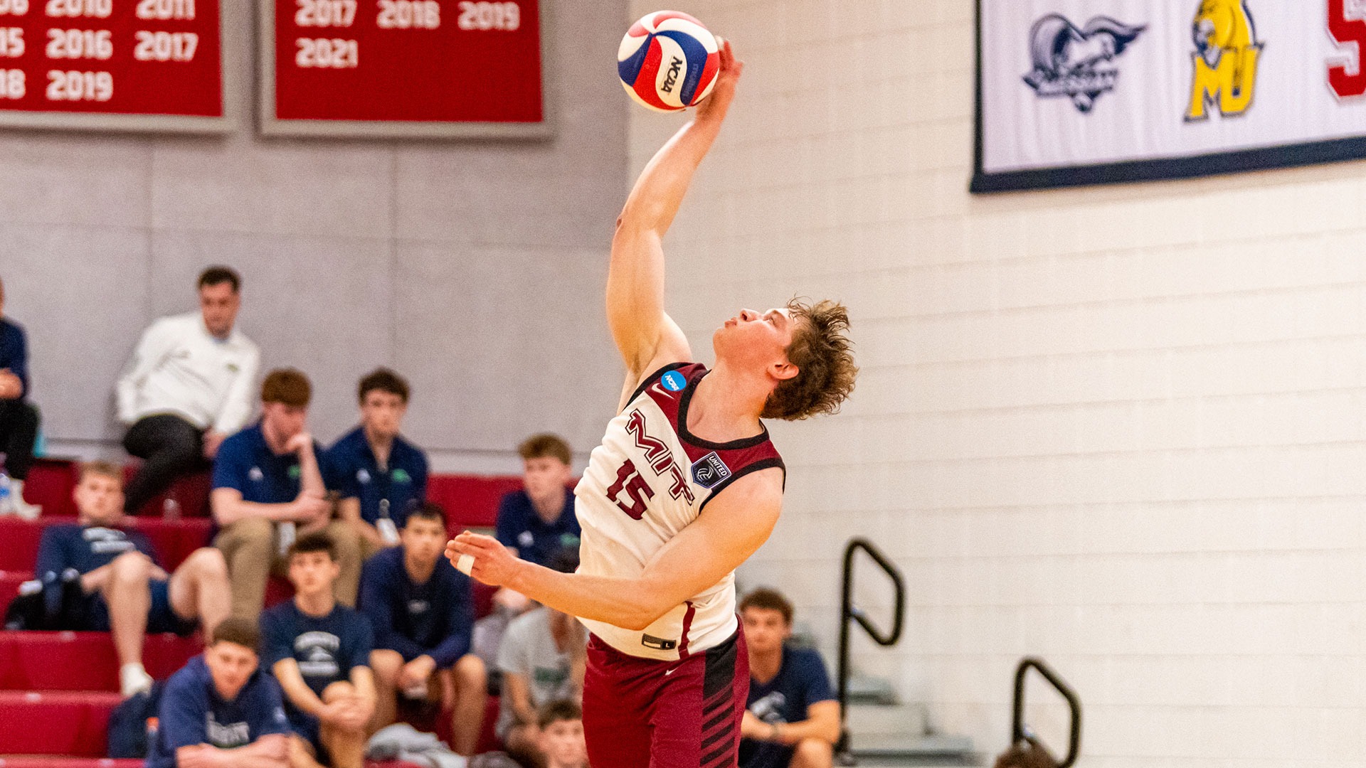 Braeden Baker serving a volleyball