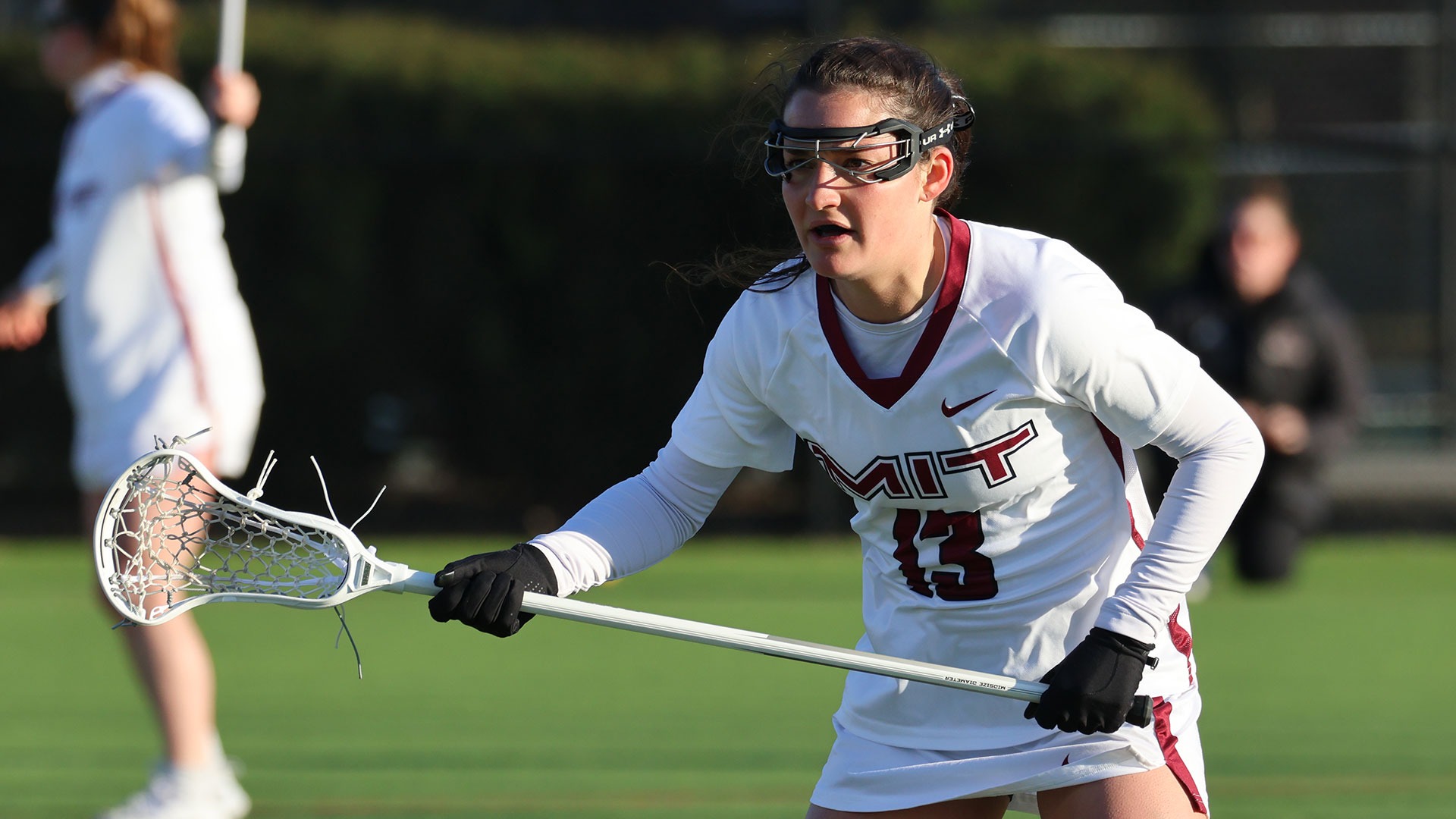 Gwen Flusche standing on the lacrosse field while holding her stick