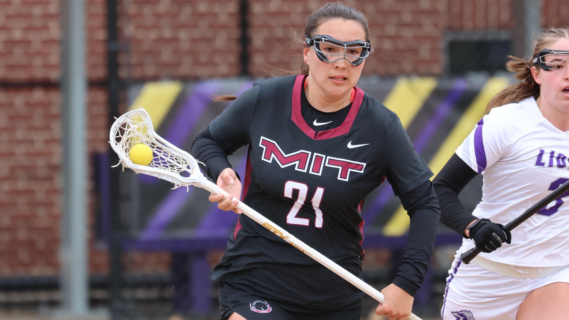 Loralei Quinn running down the field with the ball in her lacrosse stick