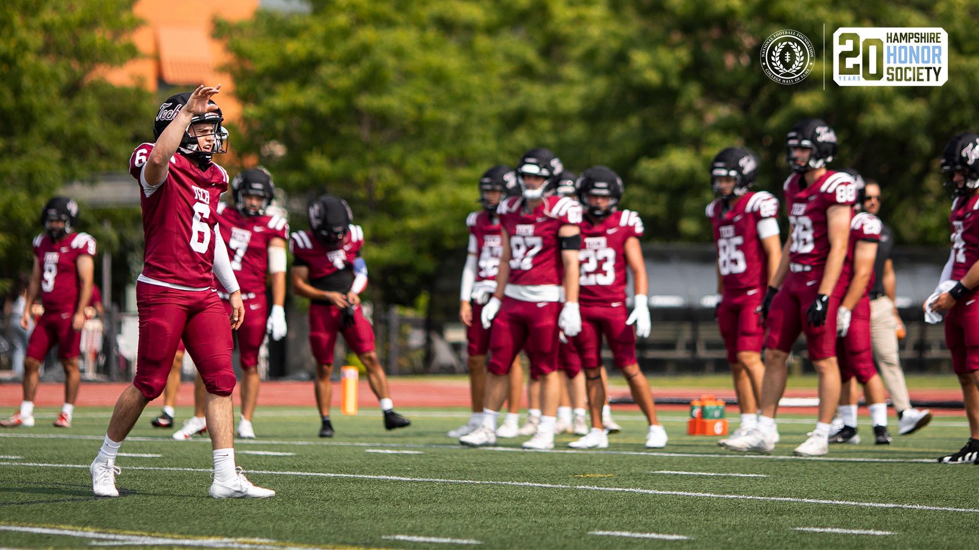 The MIT football team during pregame warm-ups, image feature NFF Hampshire Society 20th anniversary logo