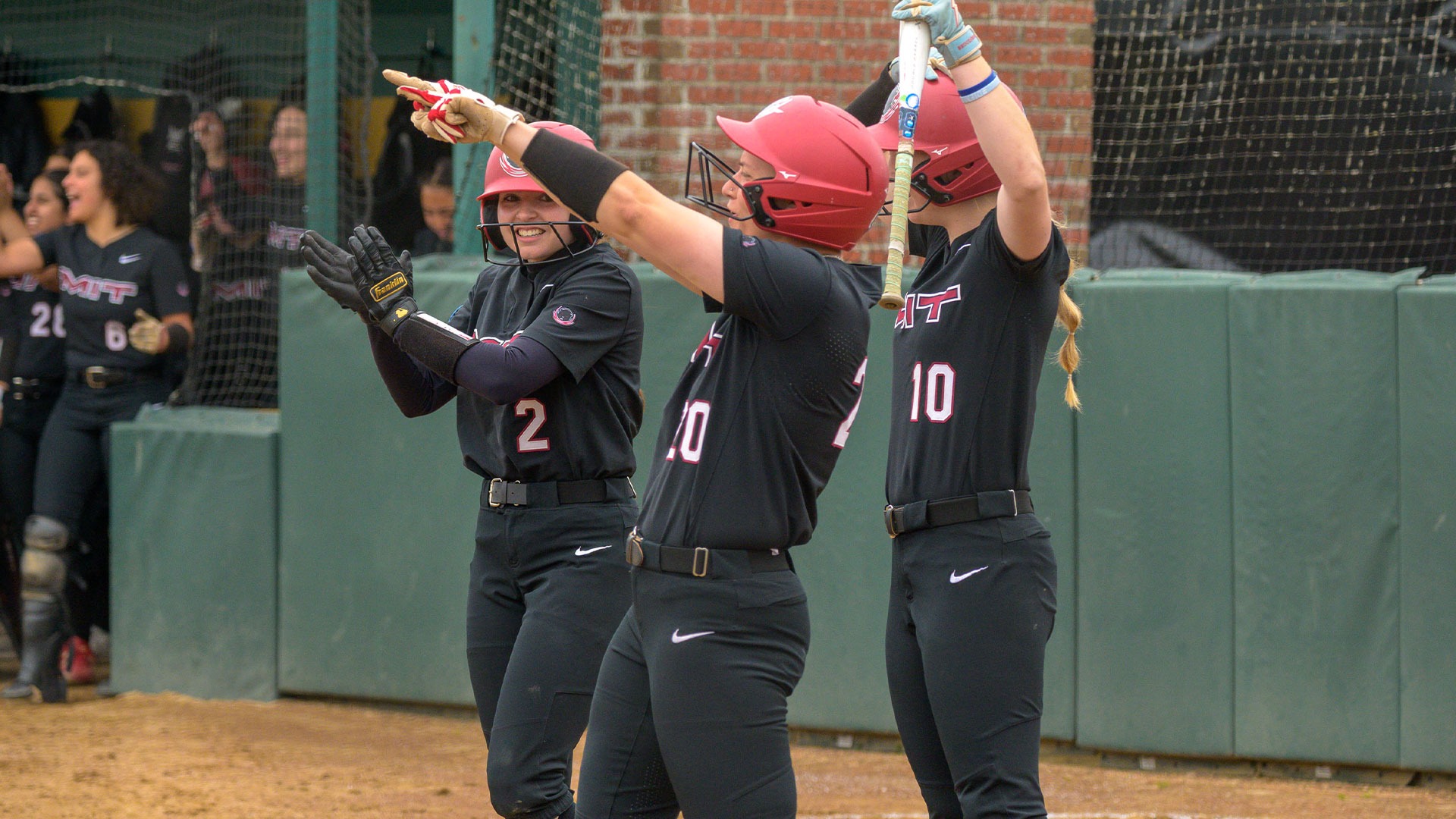 Members of the MIT softball team cheering at home plate
