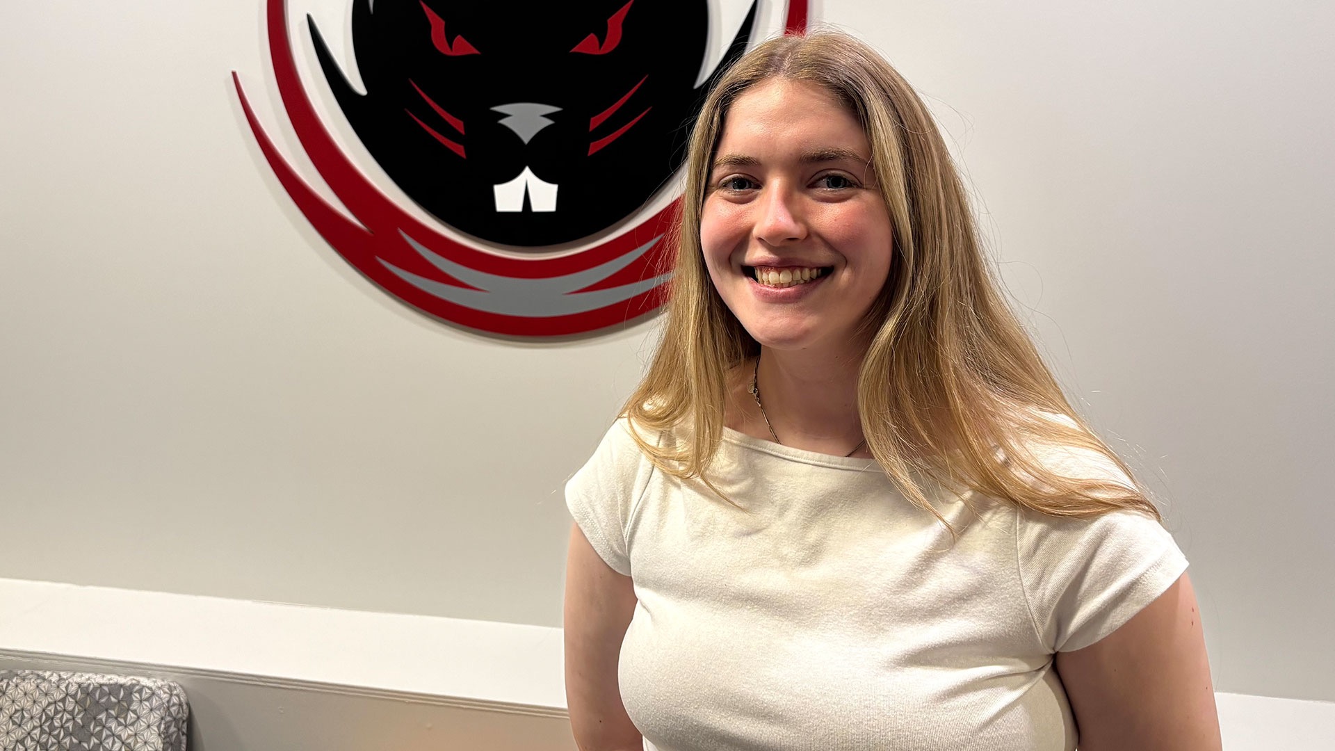 Ciara O’Malley smiling in front of the MIT Athletics logo